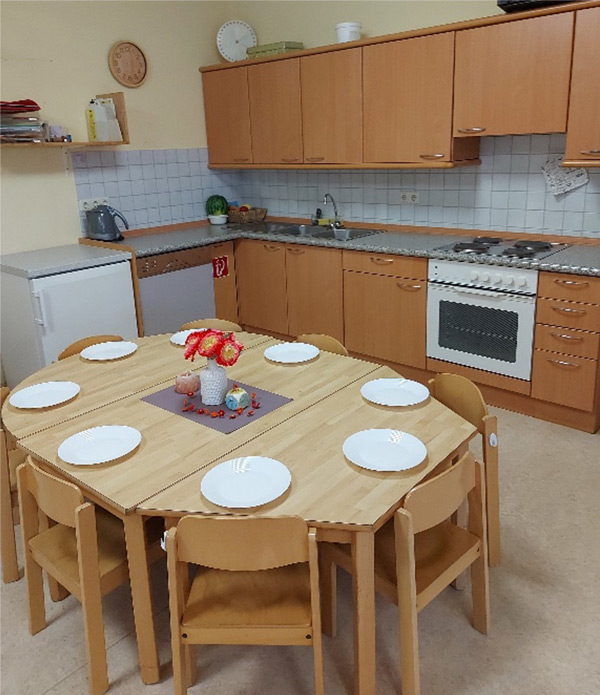 An dem großen Tisch neben der Küchenzeile finden acht Kinder einen Platz und können gleichzeitig Brotzeit machen.